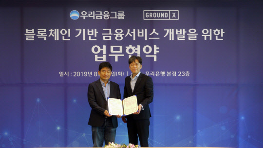 우리금융그룹은 지난 20일 서울 중구 회현동 본사에서 그라운드X와 블록체인 기반 금융서비스 개발을 위한 업무협약을 체결했다. 황원철 우리금융지주 디지털총괄 겸 우리은행 디지털금융그룹장(오른쪽)과 한재선 그라운드X 대표와 기념촬영을 하고 있다.  우리은행 제공